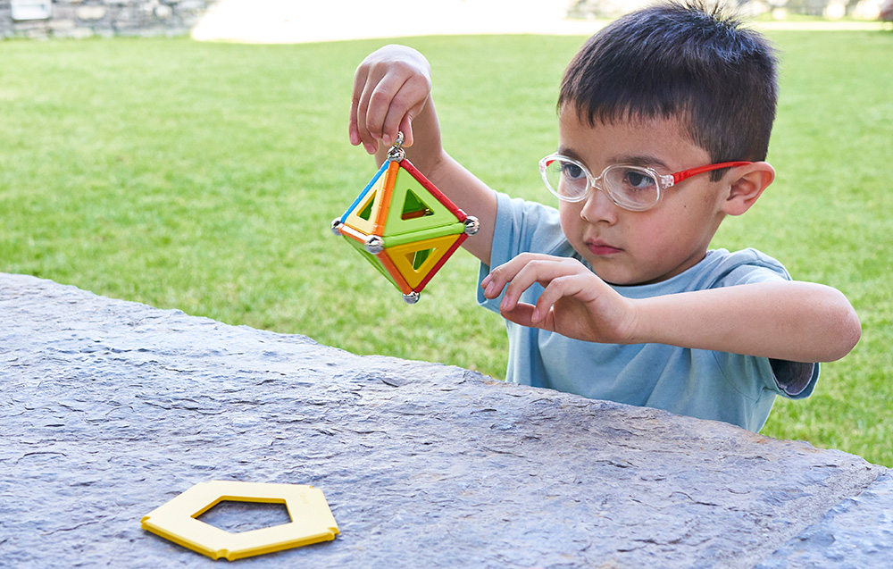 Enfant jouant avec le set Geomag Supercolor Panels Recycled