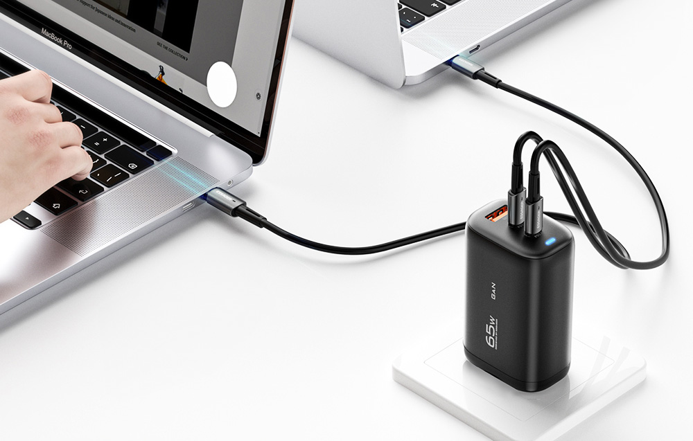 Chargeur Essager connecté à une prise sur une surface blanche, chargeant 2 ordinateurs portables.