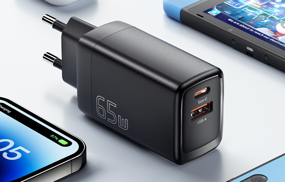 chargeur mural noir avec ports USB sur une table claire, entouré de smartphones et de la console Nintendo Switch