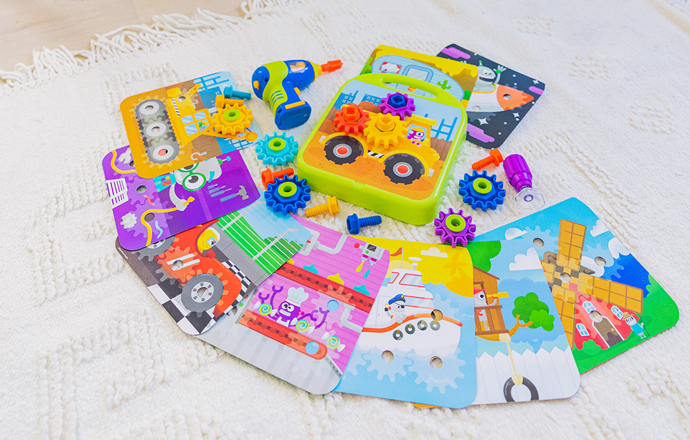 Perceuse-jouet avec kit d'engrenages sur tapis clair